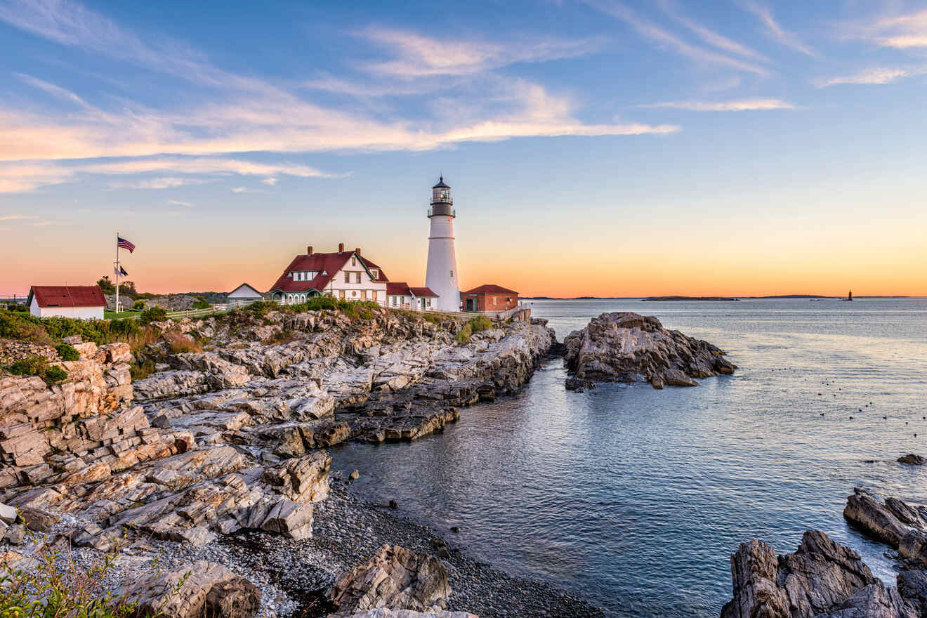 Iconic lighthouse on a rocky shore at sunset, with a calm sea and a clear sky enhancing the tranquil scenery.
